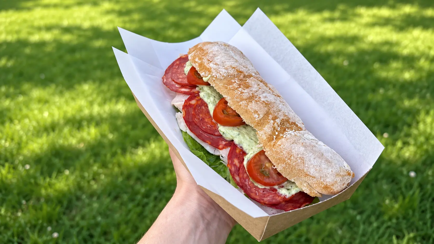 A freshly prepared filled baguette served outside at the canteen
