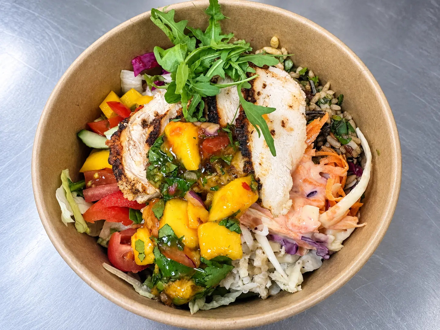 A colourful freshly prepared chicken and mango salad bowl